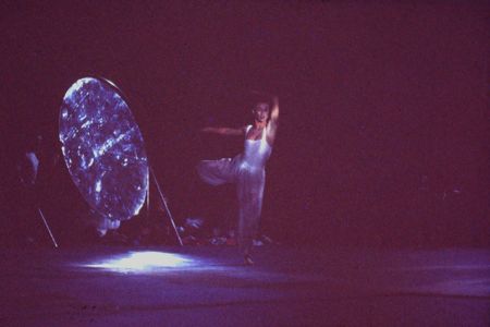 Cynthia Quinn of Momix dancing in front of the Archimedes reflector under moonlight